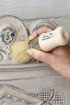 a person is using a brush to paint a piece of art