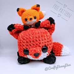 a crocheted stuffed animal is sitting on top of another knitted toy that looks like a fox