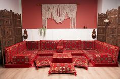 an ornately decorated living room with red couches and matching rugs on the floor