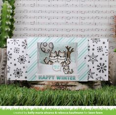 an image of a happy winter card in the grass with snowflakes on it