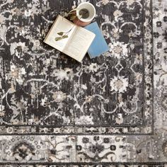 an open book and cup on top of a rug