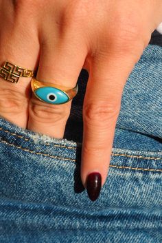 Give your digits the power to wave goodbye to negativity and beckon only admiring glances—light 'em up with this absolute classic in blue! Our fan favorite Evil Eye Ring is the good luck charm your wardrobe has been waiting, shining smartly with its invigorating sky blue evil eye lined in stately gold. Let your finger stacks start here and get ready to build a blinged-out dream that's totally, unmistakably you. Trendy Handmade Blue Rings, Trendy Handmade Blue Ring, Blue Spiritual Ring With Evil Eye, Spiritual Blue Evil Eye Ring, Spiritual Blue Rings With Evil Eye Detail, Spiritual Blue Ring With Evil Eye Detail, Symbolic Blue Ring As Gift, Symbolic Adjustable Blue Rings, Adjustable Symbolic Blue Rings