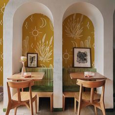 two wooden tables with chairs in front of yellow and white wallpapered walls,