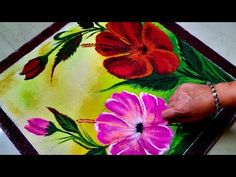 a person is painting flowers on a rug