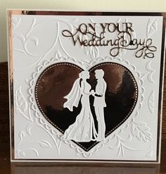 a wedding card with a silhouette of a bride and groom in a heart - shaped frame