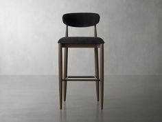 an upholstered bar stool with a black seat and backrest, in front of a gray wall