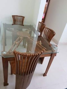 a glass table with wooden chairs around it