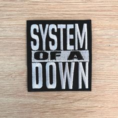 a black and white patch with the words system of a down on it's side