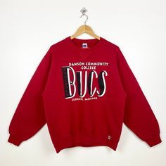 90s Dawson Community College Bucs Crewneck Sweatshirt Print Logo Red Color Men's L - Made in Mexico - Materials : Cotton, Polyester  - Tag Reads : L Kindly see the actual measurements (All measurements were taken lying flat) - Actual size manual measurements * Width (Armpit to armpit) : 23 inches * Length (Shoulder to end of garment) : 26 inches * Sleeve length : 23 inches - Condition : * Vintage condition 9/10 (90%) * Free from stain tear and major defect - Shipping : * DHL Express/FedEx Express = 3-6 business day arrived * Please PROVIDE your PHONE/CONTACT NUMBER for SHIPPING/DELIVERY purpose DON'T FORGET TO VISIT MY SHOP FOR MORE GREAT STUFF, THANK YOU. Retro Red Cotton Sweatshirt, Red Retro Cotton Sweatshirt, 90s Style Red Sweatshirt With Letter Print, Vintage Red Crew Sweatshirt, 90s Red Letter Print Sweatshirt, 90s Style Red Letter Print Sweatshirt, Red Vintage Crew Sweatshirt, Vintage Red Crew Neck Tops, 90s Red Cotton Sweatshirt