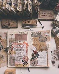 an open book sitting on top of a table covered in lots of different types of papers