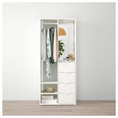 an open white closet with clothes hanging on the door and drawers in front of it