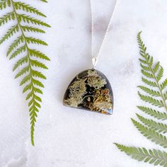 This handmade eco-resin necklace encases small Lichen pieces collected from fallen branches in Daylesford, Victoria. With a black background to accentuate the vivid details of the botanical, this necklace will forever remind you of a little piece of the forest. Housed in a clear eco-resin on a black background, the pendant is 30mm x25mm, on an 18"/45.7cm Sterling Silver necklace. As each piece is made by hand, and no two botanicals are alike, please allow for slight variations, which make for a Nature-inspired Black Jewelry Gift, Black Round Pendant Necklace Nature-inspired, Black Nature-inspired Necklace For Gift, Nature-inspired Amber Pendant Necklace, Unique Necklace With Natural Inclusions In Round Pendant, Nature-inspired Pendant Necklace For Healing, Unique Amber Resin Necklace, Unique Amber Resin Necklaces, Botanical Resin Jewelry With Natural Inclusions