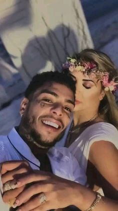 a man and woman are posing for the camera with their hands on each other's shoulders