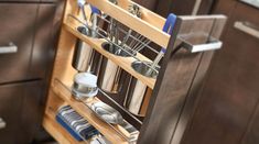 an open cabinet with utensils and other kitchen items in the bottom drawer,