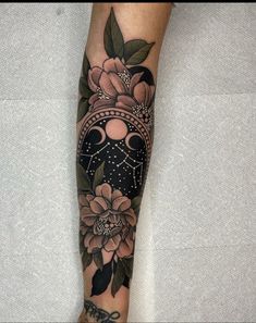 a woman's leg with flowers on it and a clock in the middle of her leg