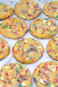 cookies with sprinkles and white chocolate chips on a marble counter top, ready to be eaten