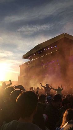 a large crowd is at a concert with their arms in the air