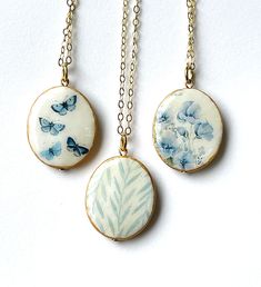 two necklaces with blue flowers and butterflies on them