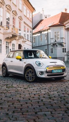 a small white car parked in front of a building