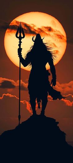 the silhouette of a person holding a spear and standing on top of a hill