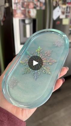 a person holding a glass dish with snowflakes on it