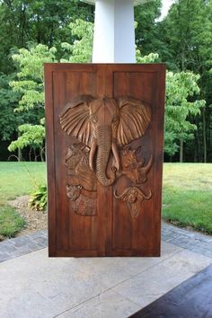 an elephant carved into the side of a wooden door with two elephants on it's sides