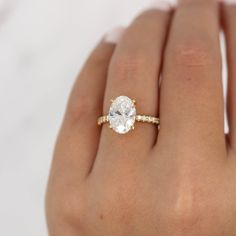 a woman's hand with a diamond ring on top of her finger and an engagement band