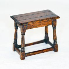 an old wooden stool sitting on top of a white floor