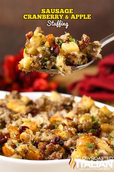 sausage, cranberry and apple stuffing in a white bowl with a serving spoon