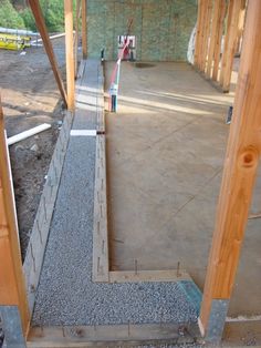 the inside of a building being built with wooden framing and concrete flooring in place