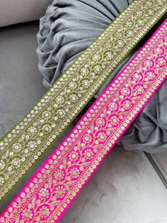 two pink and green sashes sitting next to each other