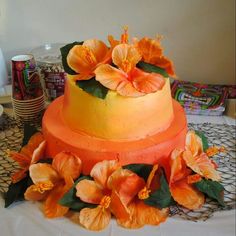 there is a cake with orange flowers on the top and bottom, sitting on a table