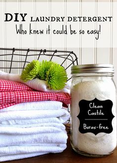 laundry deterent and towels sitting on top of a wooden table next to a basket