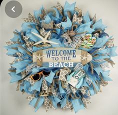 a welcome to the beach wreath with blue and white ribbons, starfish, flip flops, sunglasses, and other items