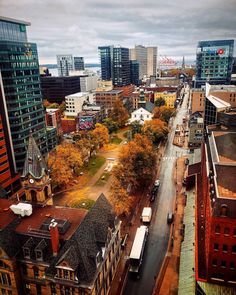 an aerial view of a city with tall buildings and lots of trees in the foreground