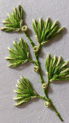 three small green leaves on a white cloth