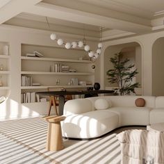 a large white couch sitting in a living room next to a book shelf filled with books