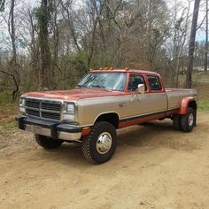 a brown truck parked on top of a dirt road