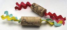 two wine corks with colorful streamers on them