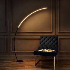 a black chair sitting in front of a floor lamp