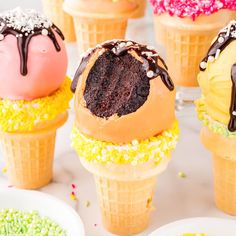 several ice cream cones with chocolate frosting and sprinkles on them are shown