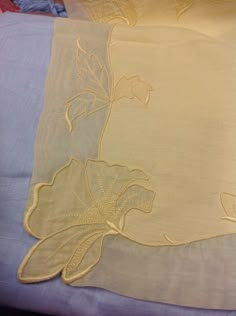 two sheets with embroidered flowers on them