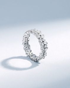 a diamond ring is shown on a white surface with the light reflecting off it's side