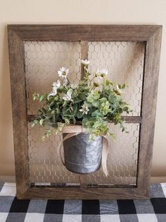 a metal bucket filled with flowers on top of a table