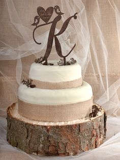 a three tiered wedding cake with a bride and groom topper sitting on a tree stump