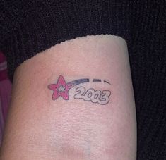 a woman's arm with a tattoo that reads 2013 and has a star on it