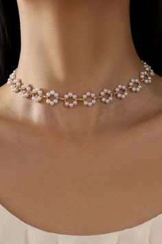 Classic Flower Pearl Choker Necklace, this exquisite necklace features lustrous pearls interspersed with delicate flower design, creating a harmonious blend of classic beauty and modern charm. The pearl sits gracefully around the neck, making it a perfect accessory for any occasion. Matching Bracelet SKU# 40B114 Product Details:length: 16"charm: .5"ext: 3" Ball Chain Extclasp: Lobster Clawmetal finish: Gold Platedproduct: Lead & Nickel Compliantanti-tarnish: Double E-coating Pearl necklace | Flo Trendy Pearl Necklace, Elegant Pearl Flower Necklace With Pearl Chain, Elegant Gold Pearl Choker, Flower Shaped Pearl Chain Necklace, Modern Pearl Necklace Design, Elegant Flower-shaped Necklace With Pearl Drop, Elegant Flower-shaped Pearl Chain Necklace, Modern Pearl Necklace, Classic Flower