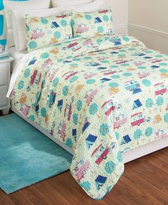 a bedroom with a bed covered in a colorful comforter and matching pillow shampoos