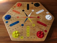 a clock made out of wooden pegs and plastic parts on top of a table