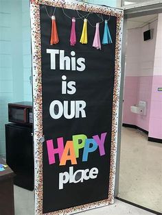 this is our happy place sign with tassels hanging from it's side